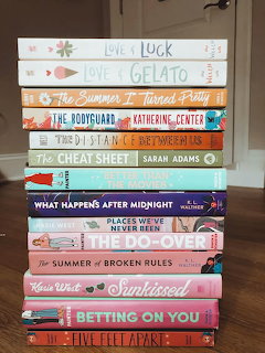 Stack of colorful romance and young adult paperback books showing their spines