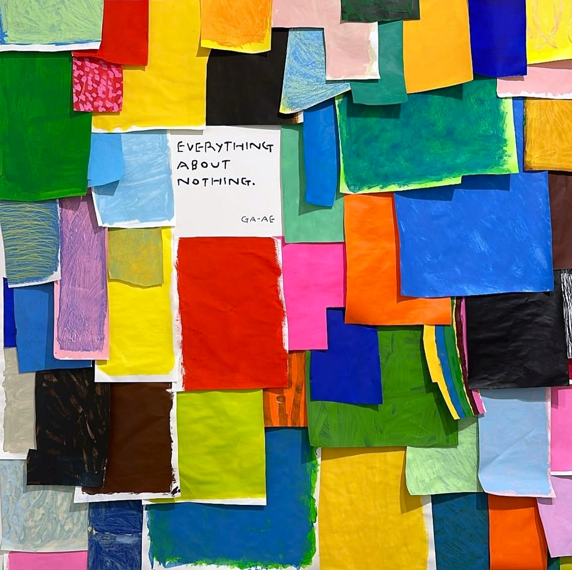 Abstract collage of colorful overlapping paper squares with handwritten text