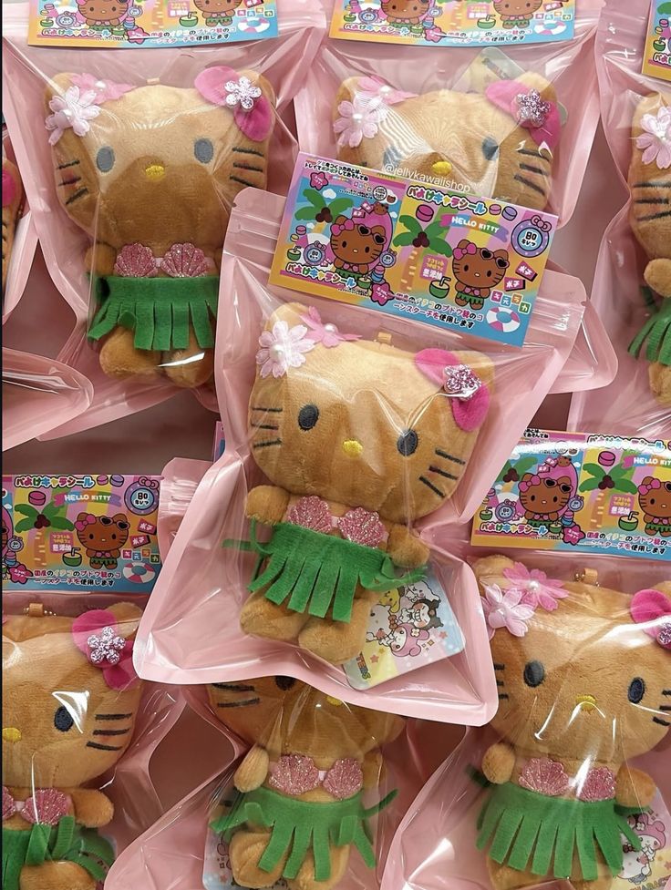 Multiple Hello Kitty plush dolls in hula dancer outfits with green skirts, wrapped in pink packaging