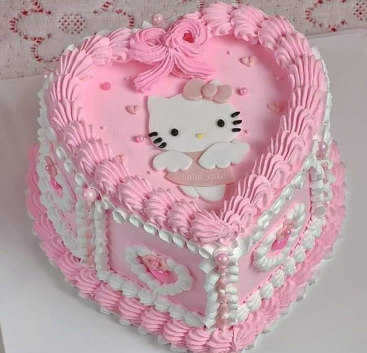 Heart-shaped pink cake with Hello Kitty face decoration and white pearl trim