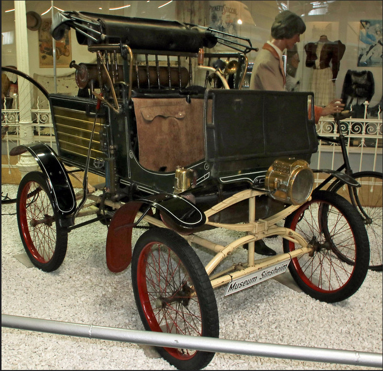 1899 Grout steam car with brass engine and wooden carriage body on display