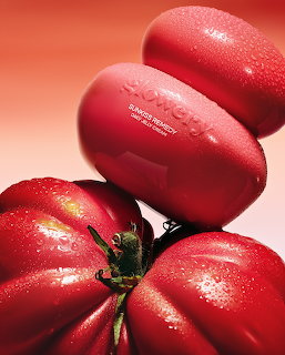 Close-up of four red tomatoes stacked with water droplets