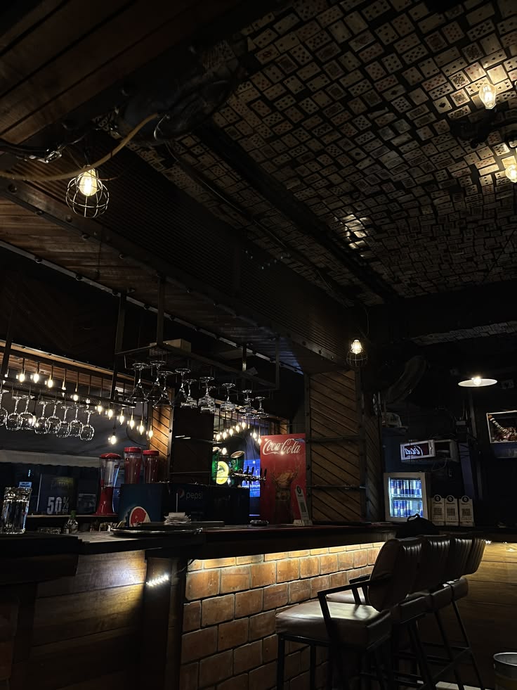 Dark moody cafe interior with ornate ceiling, bar counter, pendant lights and brick walls