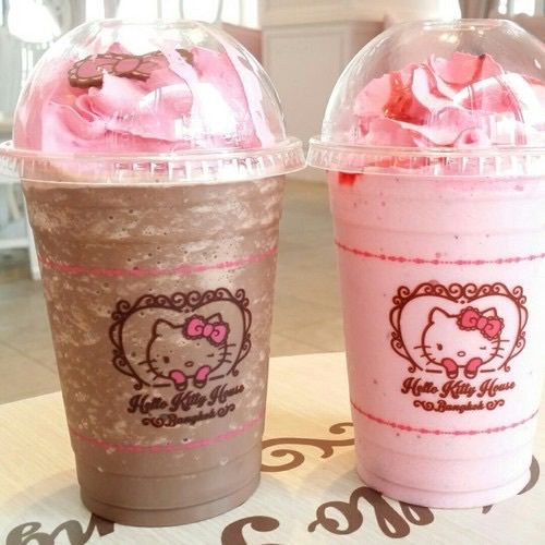 Two Hello Kitty branded frozen drinks with pink whipped cream toppings in clear plastic cups