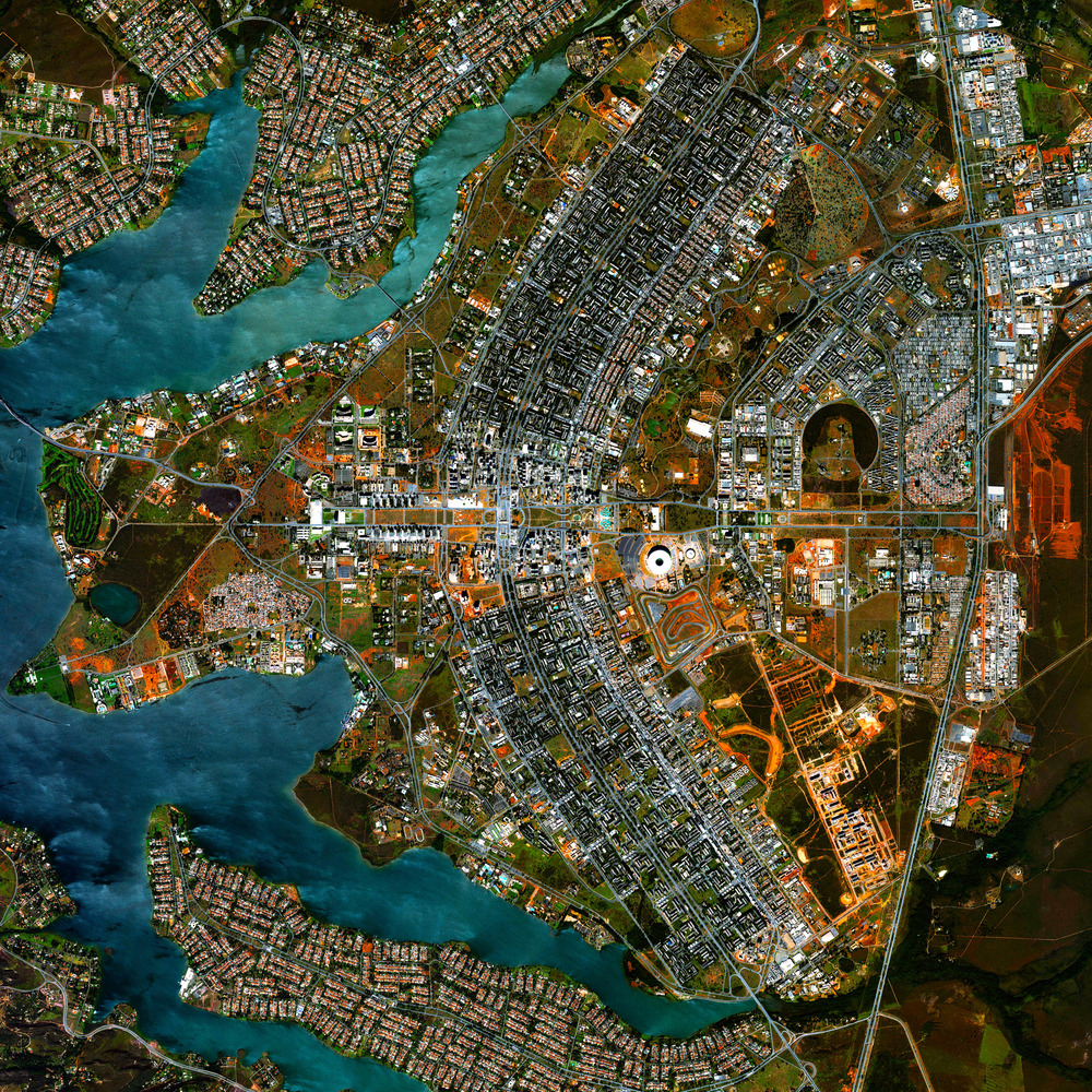 Aerial view of Brasília with city blocks, roads, and surrounding blue lakes