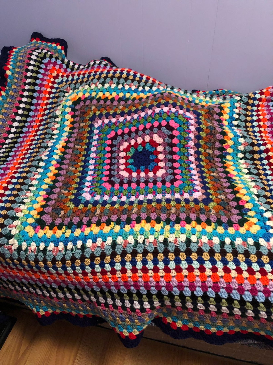Colorful handmade crochet blanket with rainbow granny square pattern