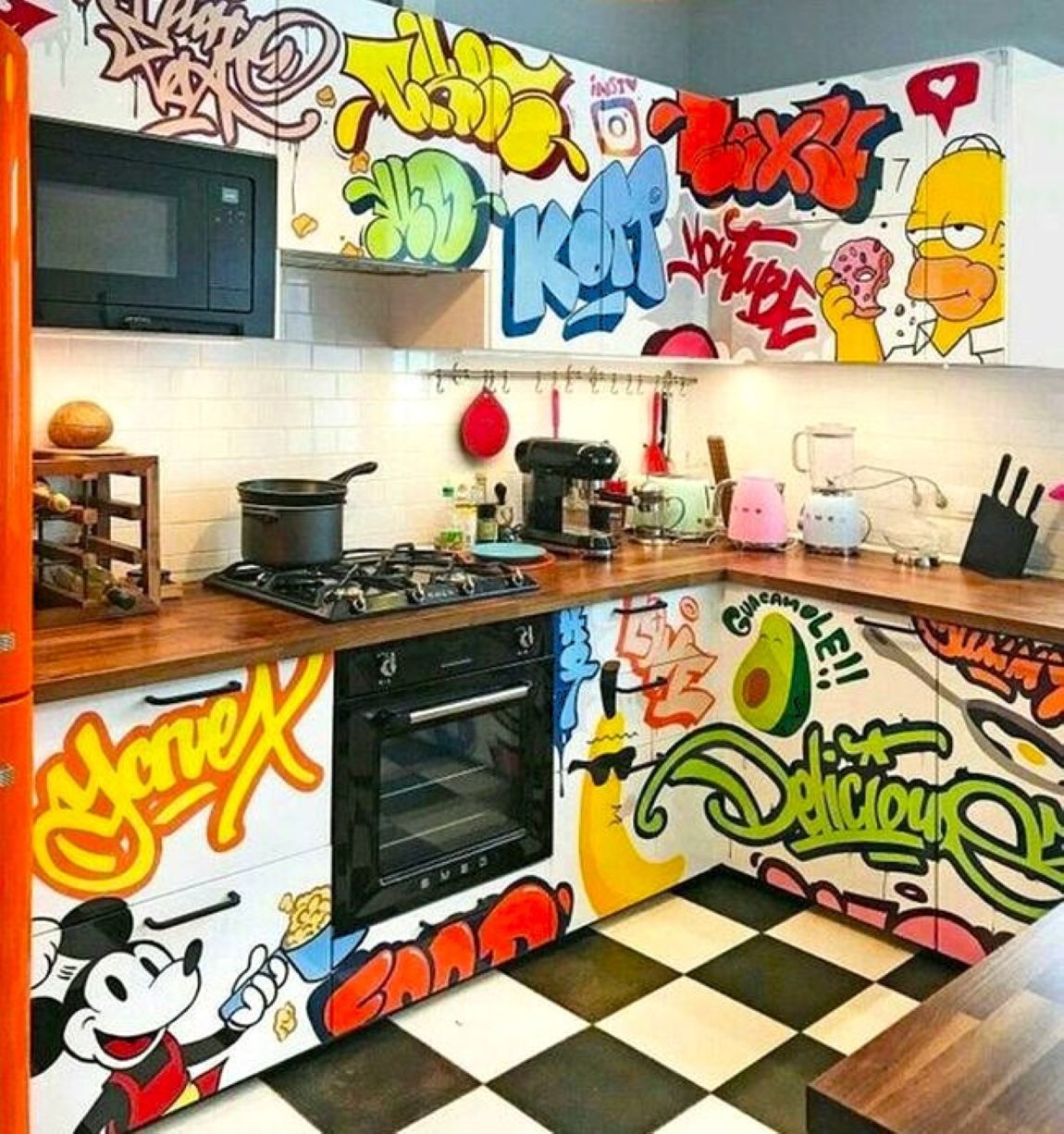 Kitchen interior with graffiti-covered cabinets and walls featuring cartoon characters and bold pop art lettering