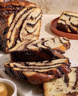 Sliced chocolate marble babka bread with swirled chocolate layers on a light surface