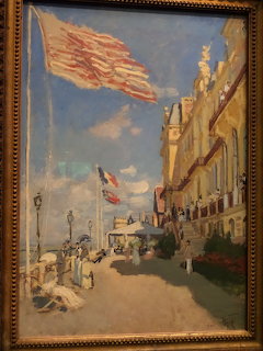 Monet painting of Hôtel des Roches Noires in Trouville with flags and figures on the promenade