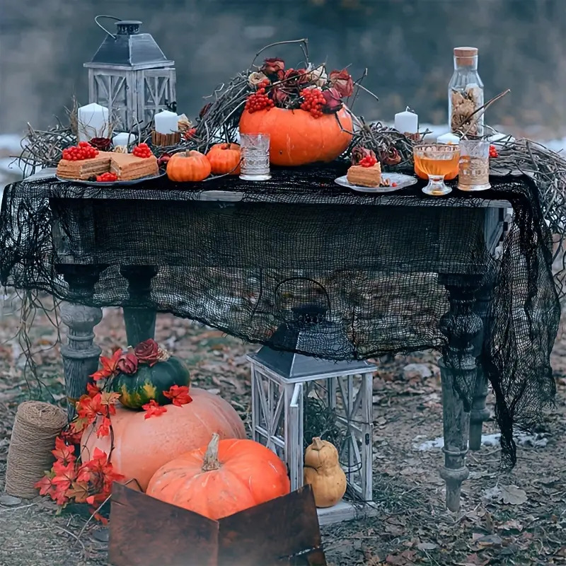 Rustic Halloween display with pumpkins, lanterns, and candles on weathered table with autumn decorations