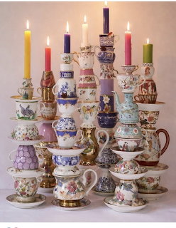 Stacked vintage teacups and saucers with candles in ornate floral porcelain