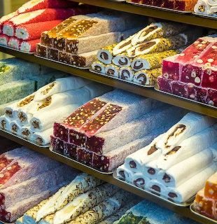 Trays of assorted Turkish delight covered in powdered sugar on a shop display