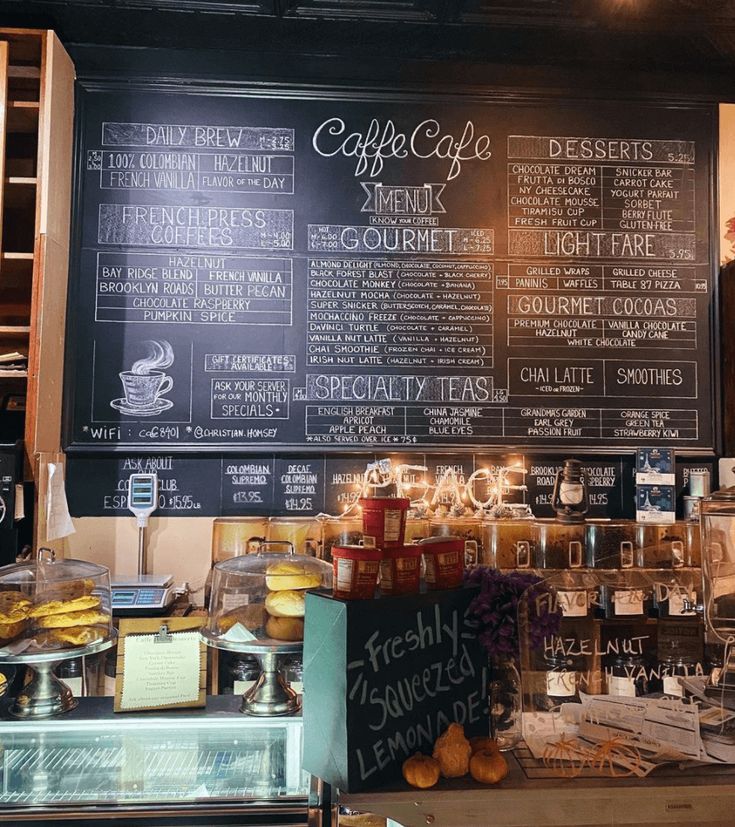 Coffee shop chalkboard menu board above a pastry display counter