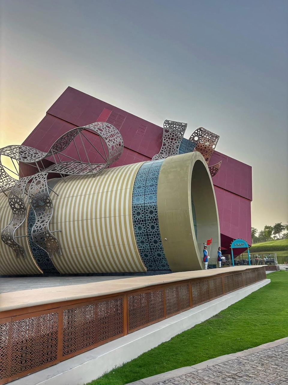 Giant gift box sculpture with metallic ribbon bow on plaza in Doha