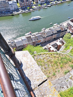 View from Dinant Citadel over a river, boats, and waterfront buildings below