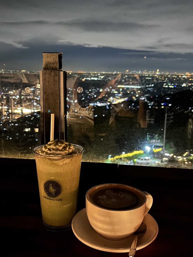 Coffee drinks on table with nighttime city view in background