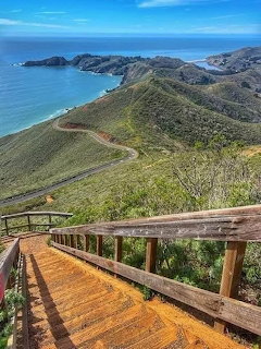 Wooden deck overlooking green coastal hills and ocean at Marin Headlands