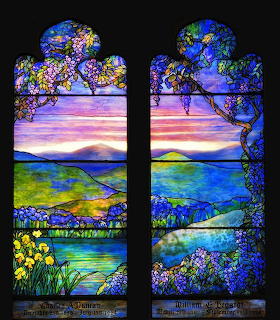 Tiffany-style stained glass window with blooming trees, water landscape, and colorful floral details