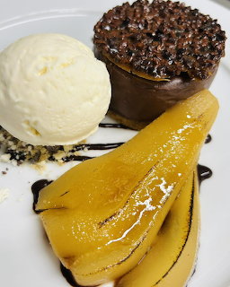 Plated dessert with chocolate mousse cup, vanilla ice cream, and caramelized pear slices