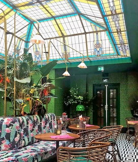 Colorful café interior with decorative glass ceiling and tropical plants