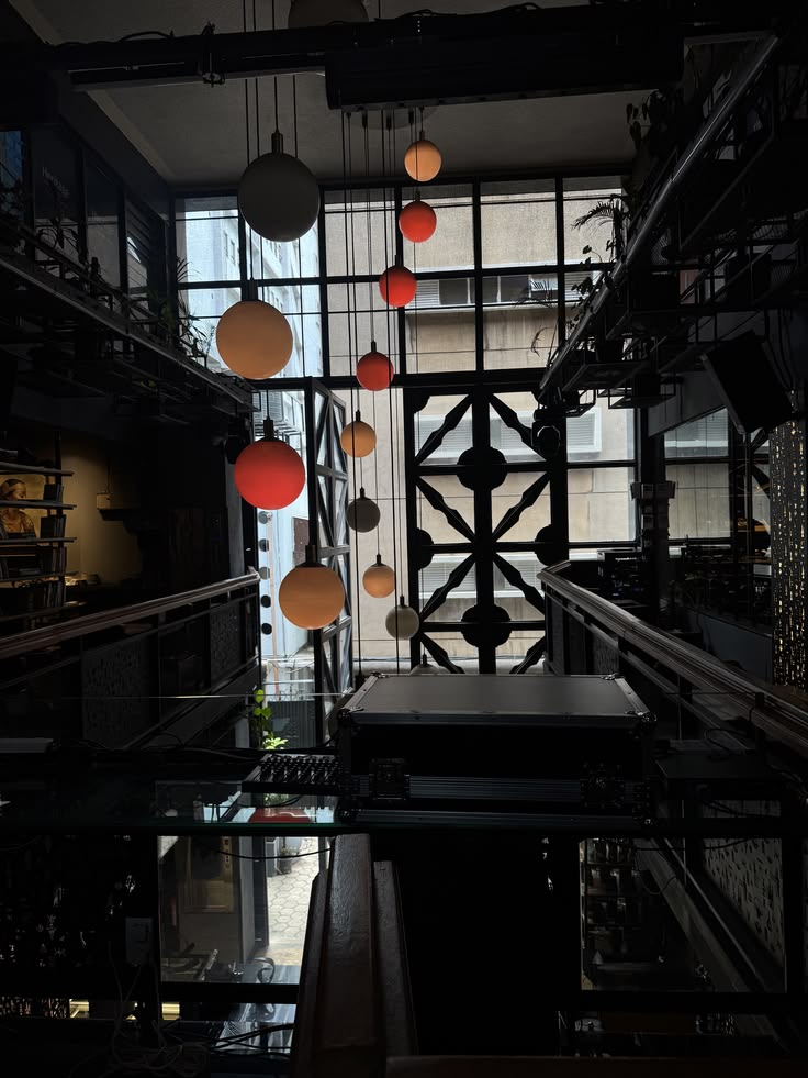 Dark modern cafe interior with colorful pendant lights and geometric glass door