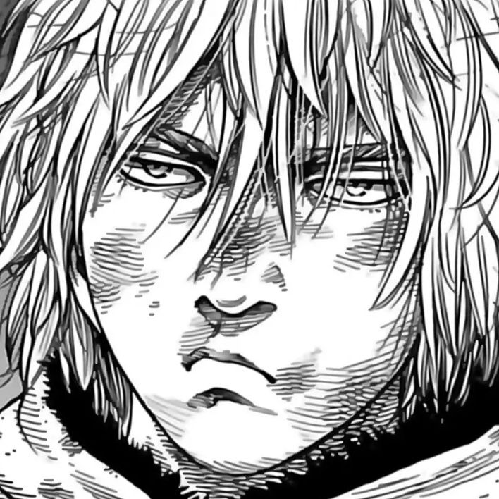 Black-and-white manga close-up of Thorfinn with messy hair and a stern expression