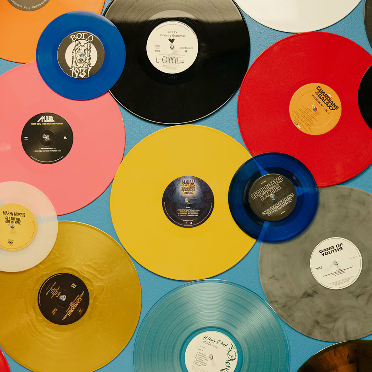 Colorful vinyl records of various sizes arranged in an overlapping flat lay