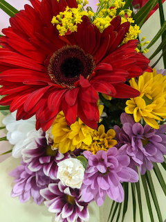 Close-up of colorful flower bouquet with red gerbera daisy, purple and yellow flowers