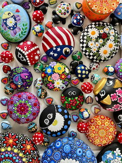 Collection of vibrant hand-painted rocks with mandala patterns, dots, flowers, and decorative designs