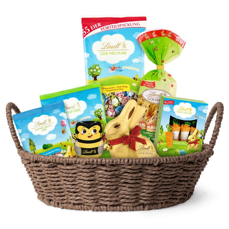 Wicker basket filled with assorted packaged snack packages and treats on a white background