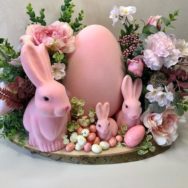 Pink Easter bunnies with large egg centerpiece surrounded by flowers and candy