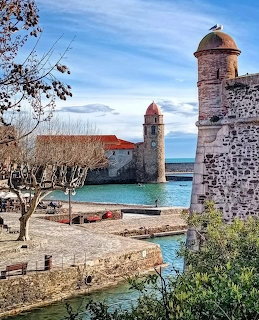 Medieval bell tower and stone fortress walls by the harbor in Collioure, France