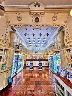 Ornate historic pharmacy interior with cream woodwork, chandeliers, and display shelves