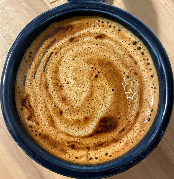 Overhead view of coffee with swirled foam pattern in blue mug