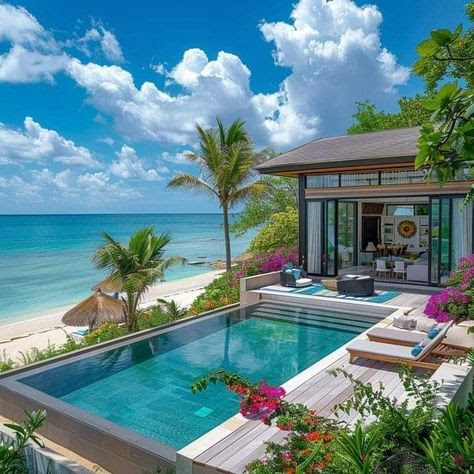 Luxury tropical villa with infinity pool, white sand beach, turquoise ocean, palm trees and pink flowers