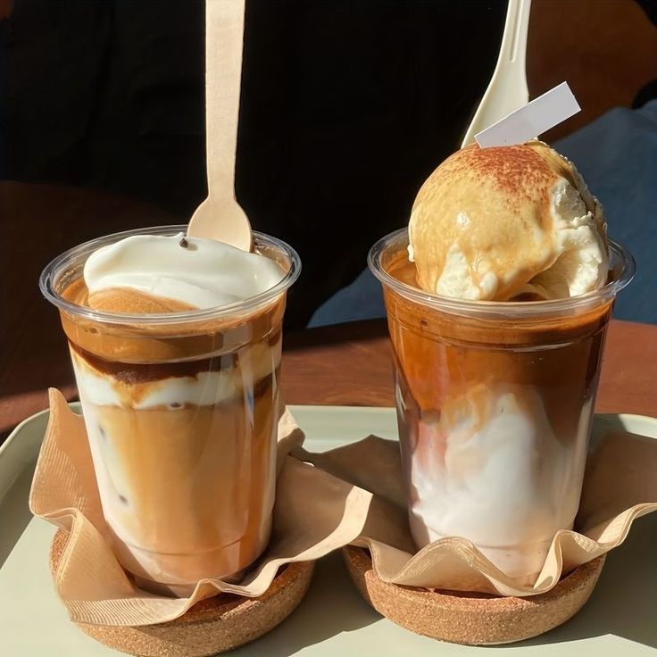 Two plastic cups of affogato coffee with vanilla ice cream on a table