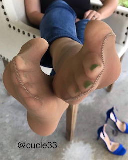 Close-up of bare feet soles facing the camera while a person sits indoors