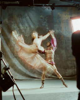 Male and female ballet dancers posing in a studio with theatrical lighting