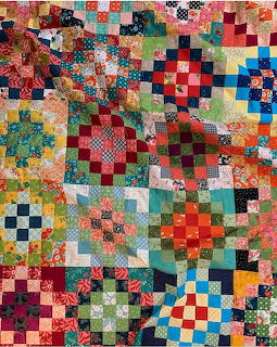 Colorful patchwork quilt with geometric fabric squares in various patterns and bright colors