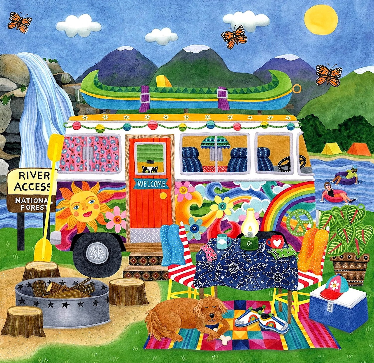 Folk art camper trailer with colorful quilts and flowers by a river with mountains and waterfall in background
