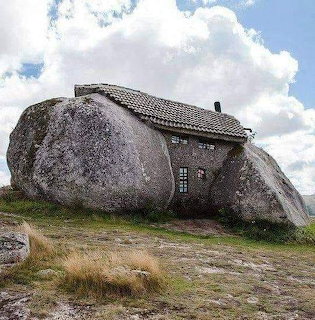 House constructed between large natural boulders with tiled roof in Portugal countryside