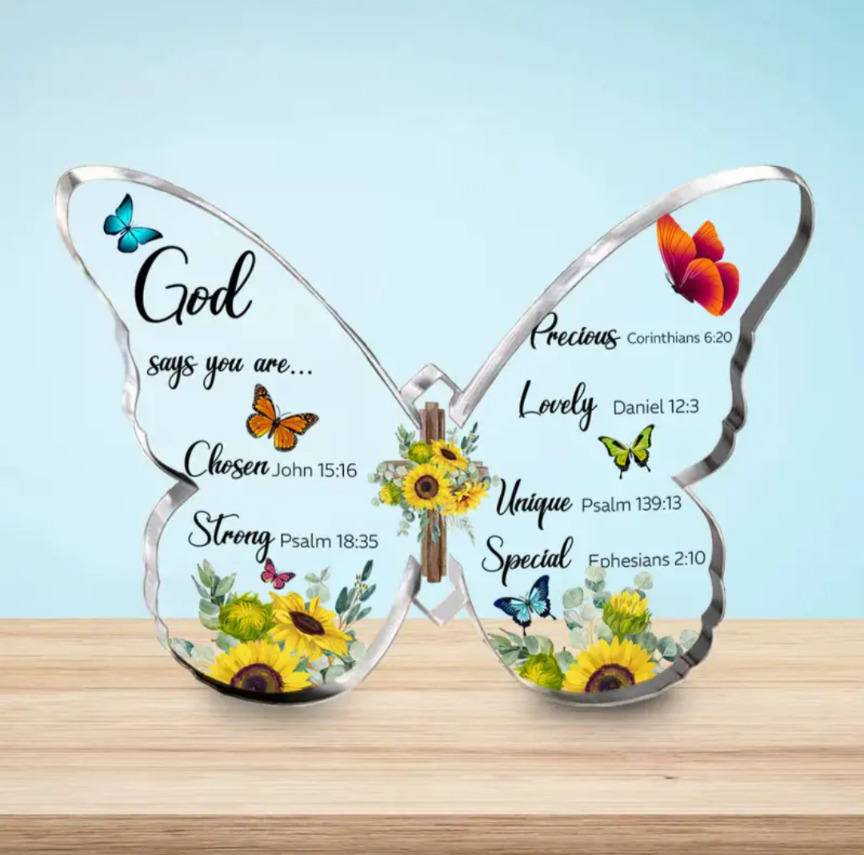 Transparent butterfly decoration with inspirational text, flowers, and birds on a wooden surface