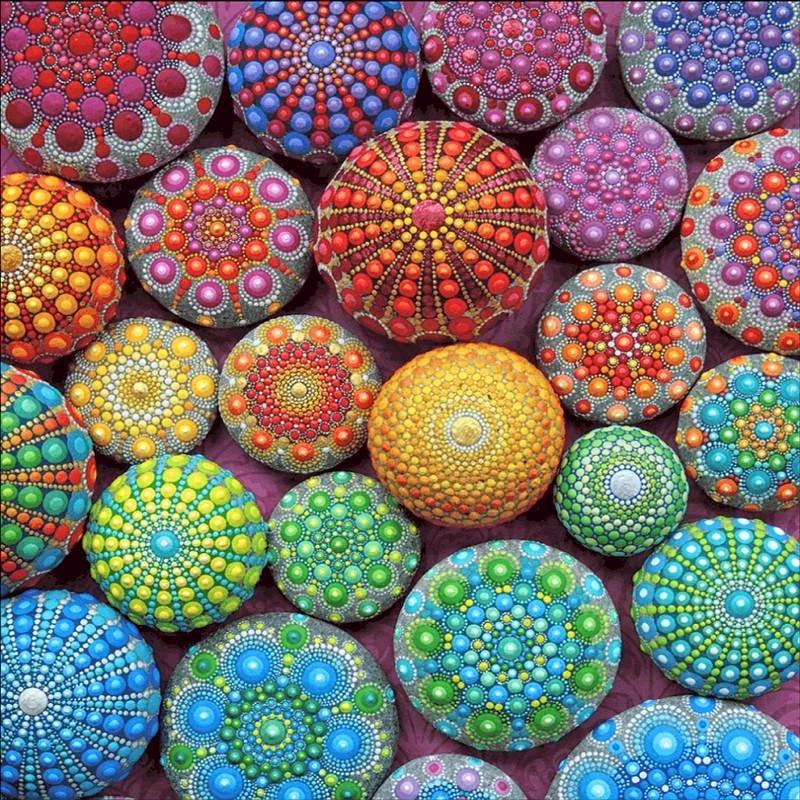 Colorful painted stones with intricate mandala dot patterns in various colors arranged together