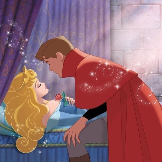 Prince Phillip leans over Princess Aurora lying on a bed in an animated fairy tale scene