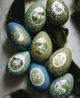 Collection of hand-painted Easter eggs with detailed miniature scenes in green and blue tones