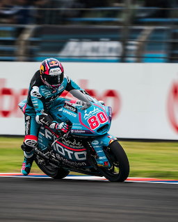 Moto2 racer number 80 on a turquoise CFMOTO bike leaning into a turn on a racetrack