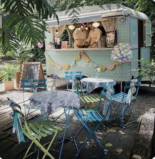 Vintage aqua trailer coffee bar with folding chairs and tropical plants