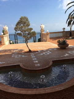 Tiled terrace with a small fountain pool, potted plants, and an ocean view