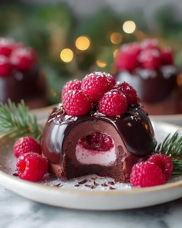 Chocolate dome dessert with fresh raspberries, evergreen garnish, and holiday lights
