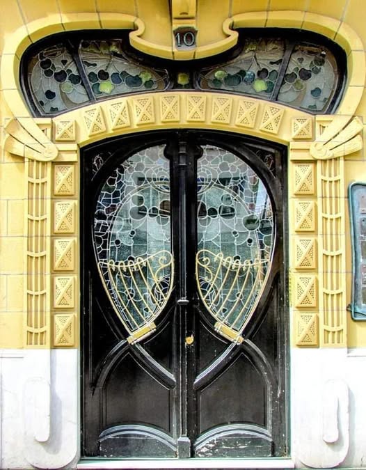 Ornate Art Nouveau wooden door with floral ironwork details
